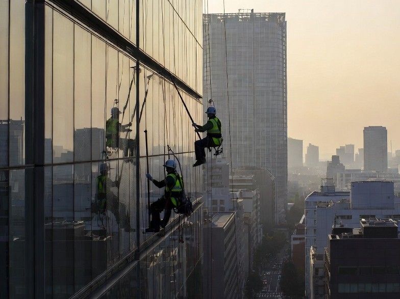 city workers cleaning glass skyscraper windows